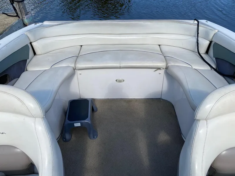 Slide: The Image of 2002 Four Winns 225 Sundowner boat interior with white seating and carpeted floor. - 6