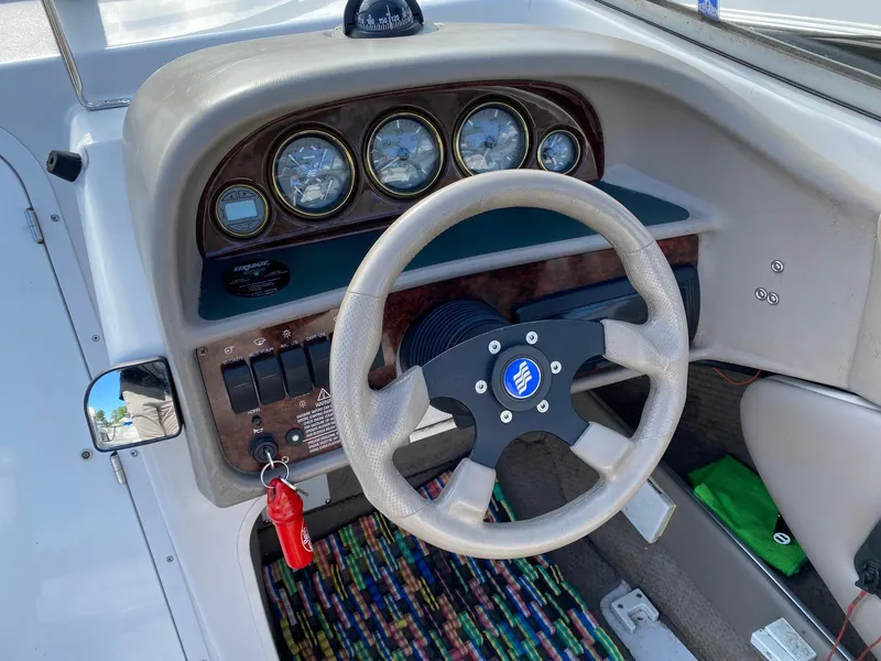 Slide: The Image of 2002 Four Winns 225 Sundowner boat dashboard with steering wheel and gauges. - 7