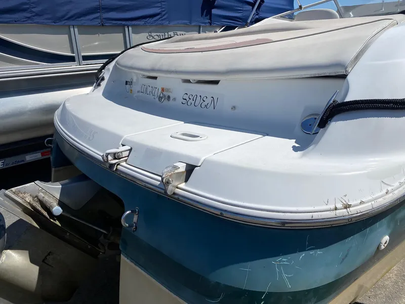 Slide: The Image of 2002 Four Winns 225 Sundowner boat, rear view, docked with visible wear. - 8