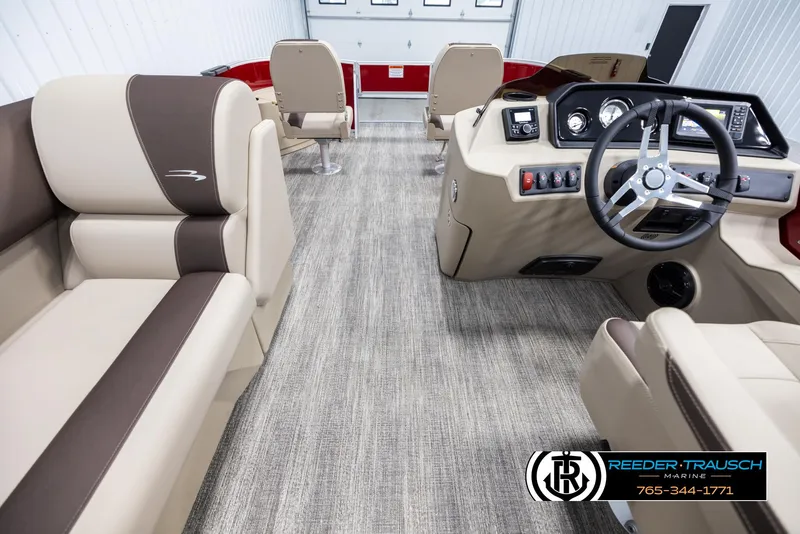 Slide: The Image of 2025 Bennington 188 SSSE boat interior with beige and brown seating, modern dashboard, and steering wheel. - 17