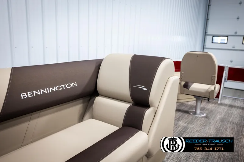 Slide: The Image of 2025 Bennington 188 SSSE boat interior with beige and brown seating in showroom. - 20