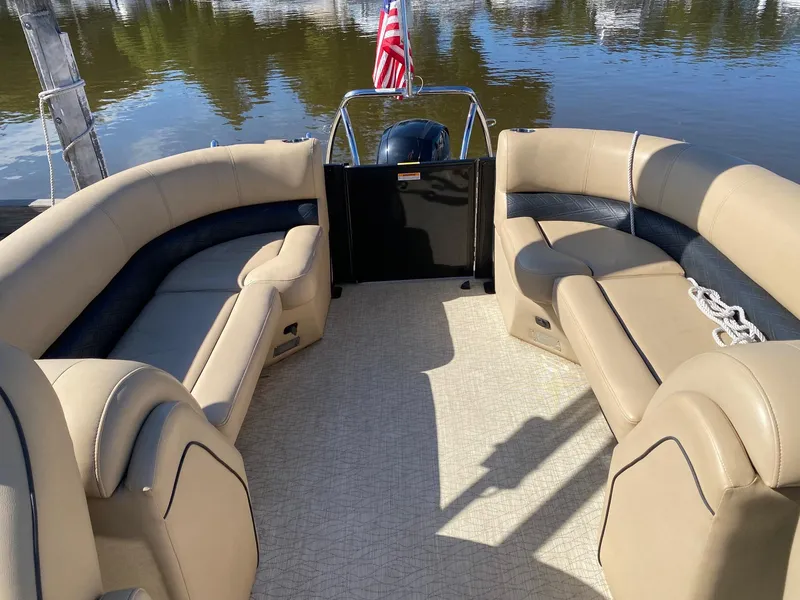 Slide: The Image of 2019 Barletta E22QC pontoon boat interior with beige seating and American flag. - 11