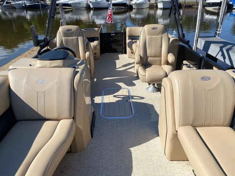 Slide: The Image of 2019 Barletta E22QC pontoon boat with beige seating, docked at marina. - 12