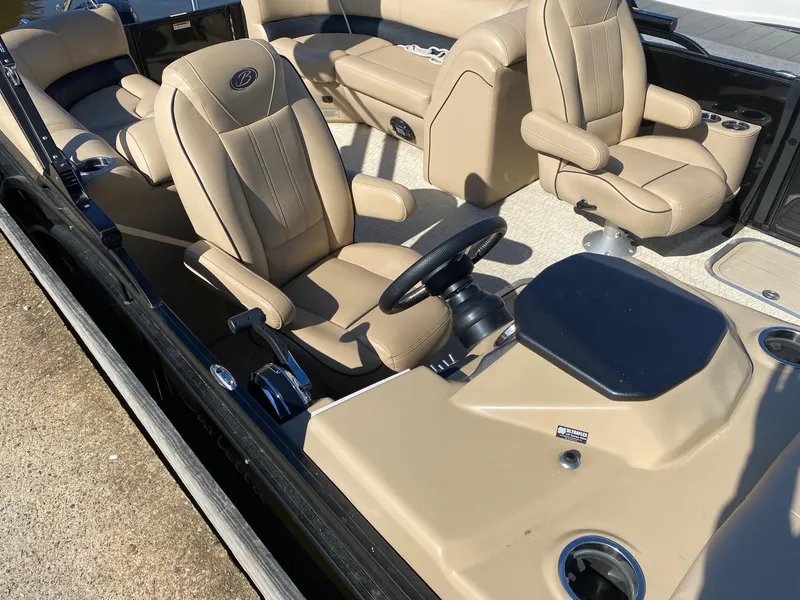 Slide: The Image of 2019 Barletta E22QC boat interior with beige leather seats and steering console. - 3