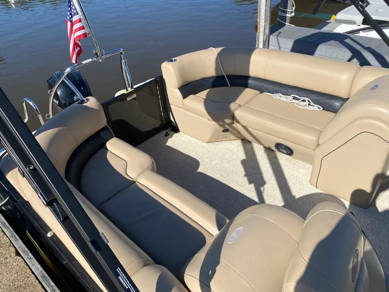Slide: The Image of 2019 Barletta E22QC pontoon boat with beige seating, docked by the water. - 4