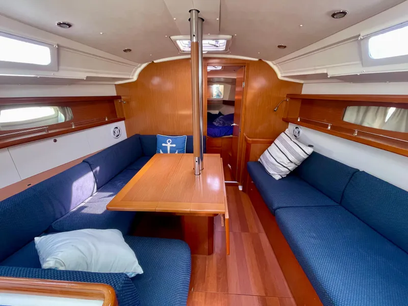 Slide: The Image of Interior of 2010 Beneteau Oceanis 37 sailboat with cozy seating and wooden finishes. - 10