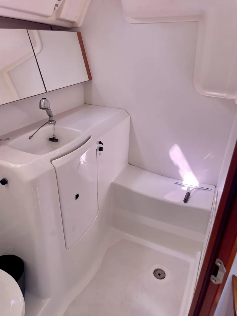Slide: The Image of 2010 Beneteau Oceanis 37 bathroom with sink, mirror, and white interior. - 22