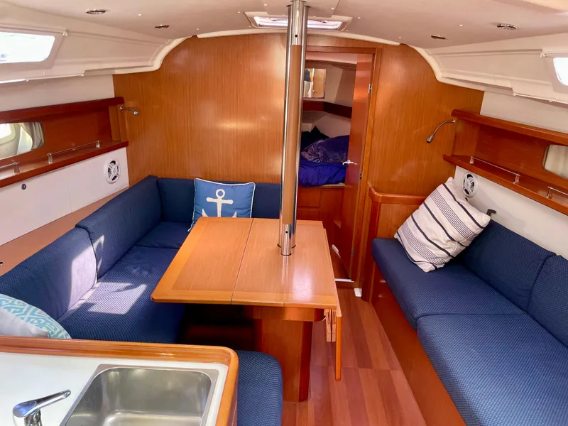 Slide: The Image of Interior of 2010 Beneteau Oceanis 37 sailboat with blue seating and wooden finishes. - 24