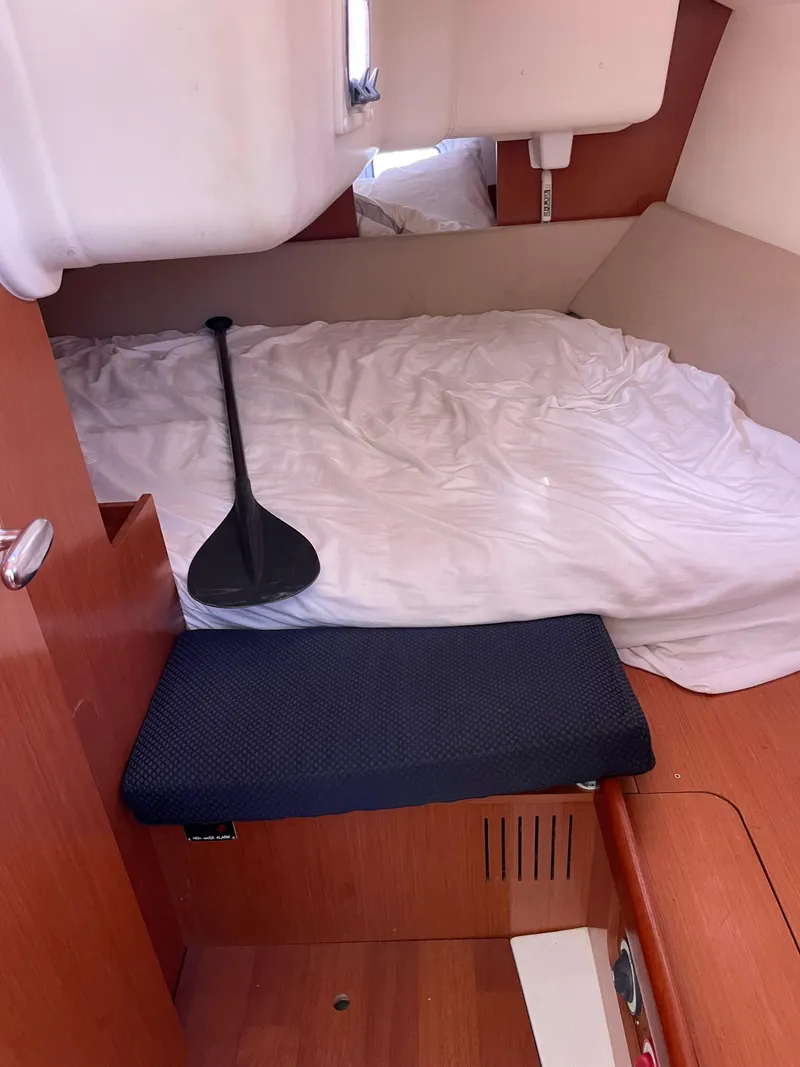 Slide: The Image of Cozy cabin interior of 2010 Beneteau Oceanis 37 sailboat with paddle on bed. - 32