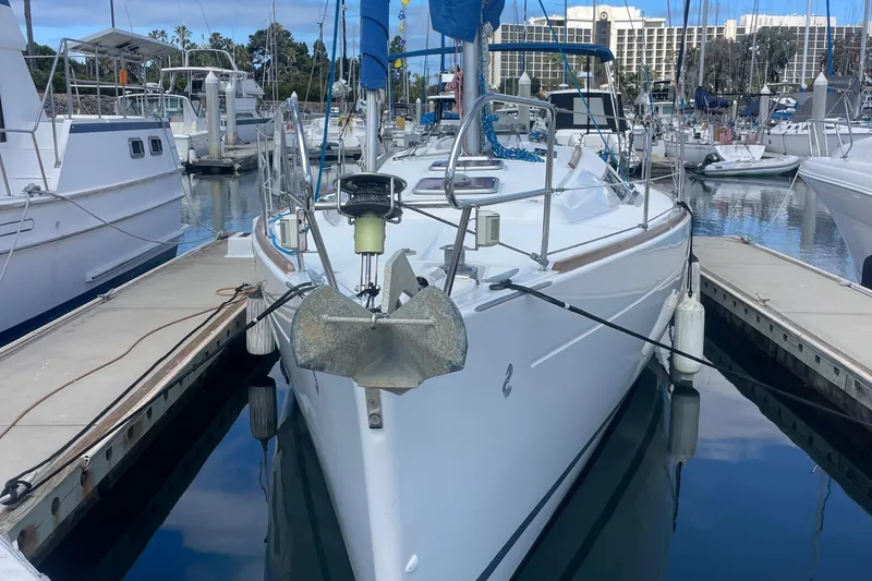 Slide: The Image of 2010 Beneteau Oceanis 37 sailboat docked in a marina, reflecting on calm water. - 4