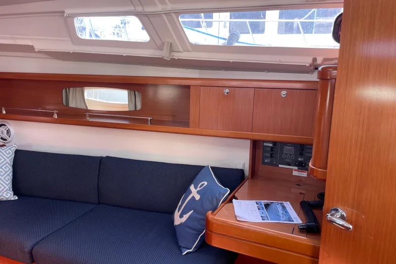 Slide: The Image of Interior of 2010 Beneteau Oceanis 37 sailboat with wooden cabinetry and blue seating. - 49