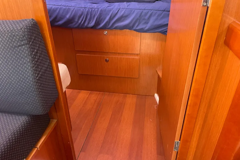 Slide: The Image of Interior cabin of 2010 Beneteau Oceanis 37 with wooden finish and blue bedding. - 56