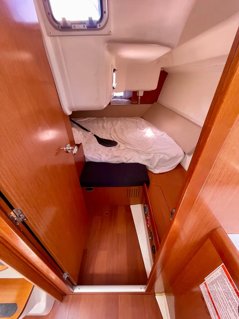 Slide: The Image of 2010 Beneteau Oceanis 37 cabin interior with wooden finish and cozy sleeping area. - 7