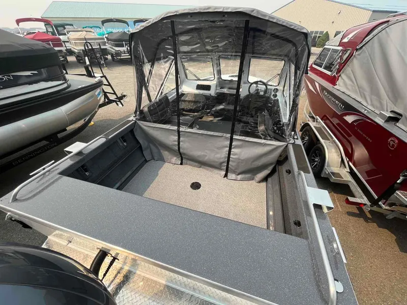 Slide: The Image of 2024 Duckworth 18 ADV XT boat with covered cockpit, displayed in a showroom. - 3