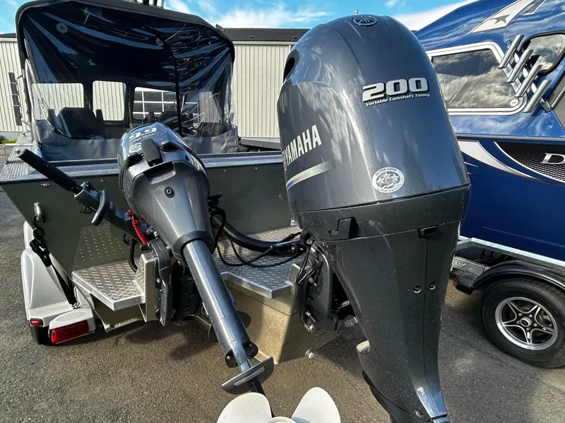 Slide: The Image of 2023 Duckworth 20 NAV SPT boat with Yamaha 200 outboard motor, parked outdoors. - 20