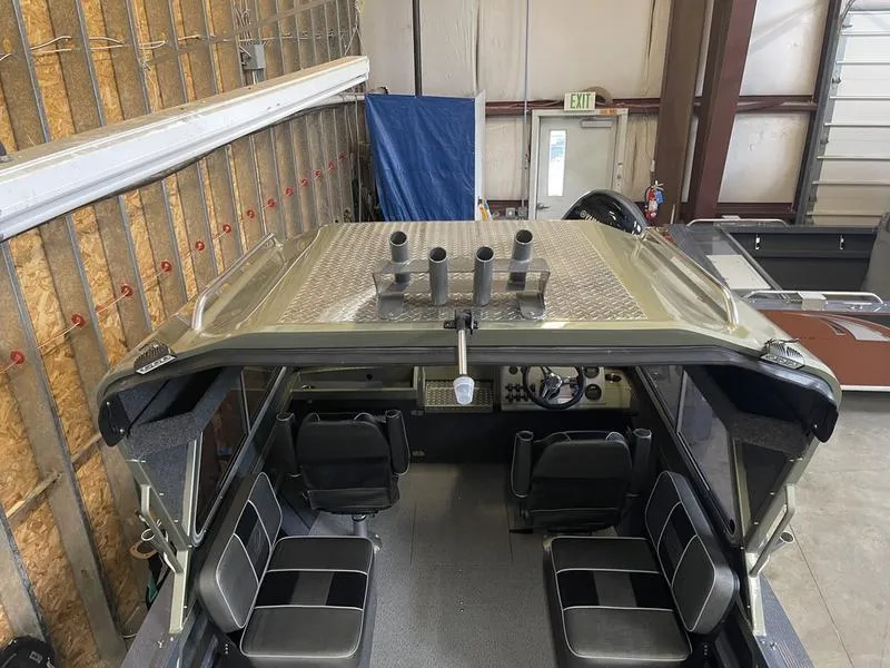 Slide: The Image of 2023 Duckworth 20 NAV SPT boat interior with seating and rod holders in a garage. - 22