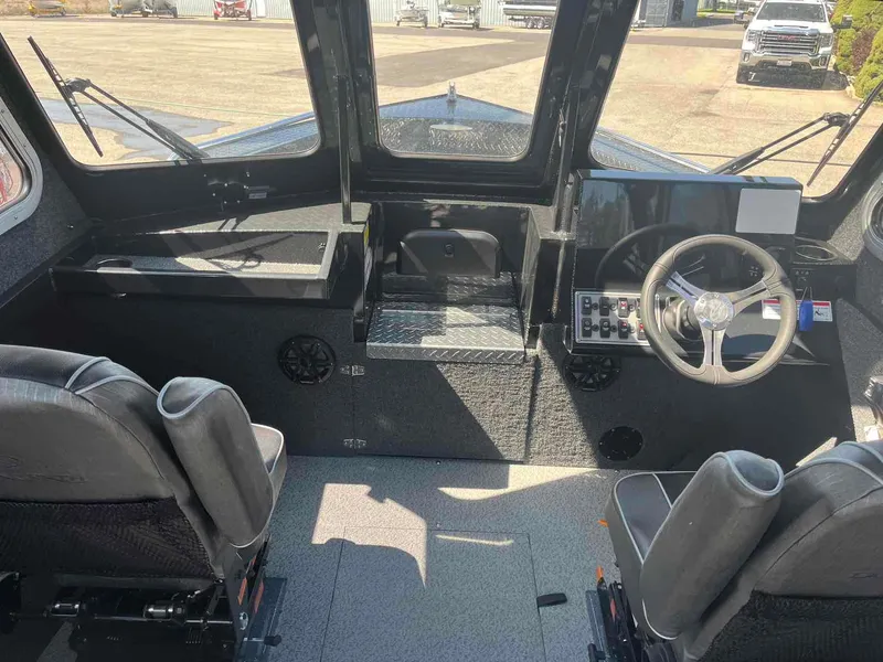 Slide: The Image of Interior of a 2024 Duckworth 21 Discovery boat, featuring steering wheel and seating. - 9