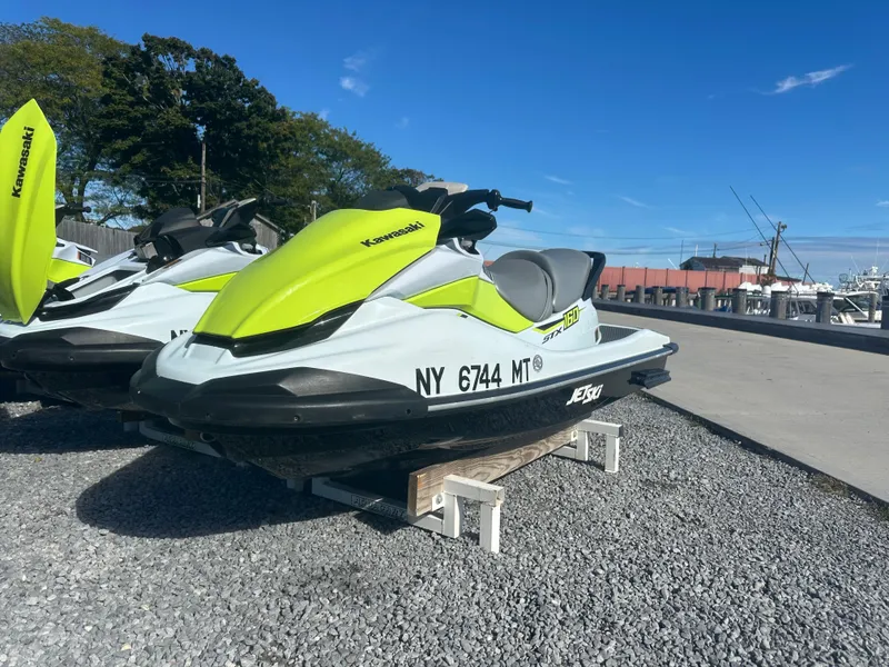 Slide: The Image of 2023 Kawasaki Jetski STX 160 parked on gravel near marina. - 1