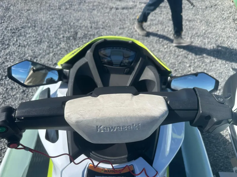 Slide: The Image of 2023 Kawasaki Jetski STX 160 handlebars and dashboard, outdoor setting. - 6