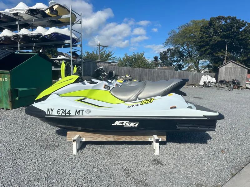 Slide: The Image of 2023 Kawasaki Jetski STX 160 on gravel, bright green and white design. - 7
