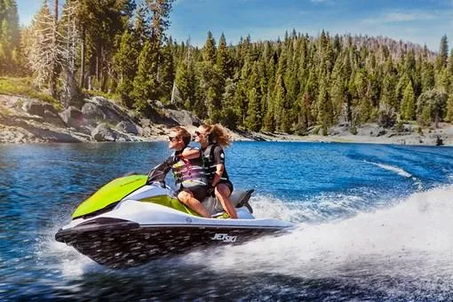 Slide: The Image of 2023 Kawasaki Jetski STX 160 speeding on a scenic lake with forest backdrop. - 9