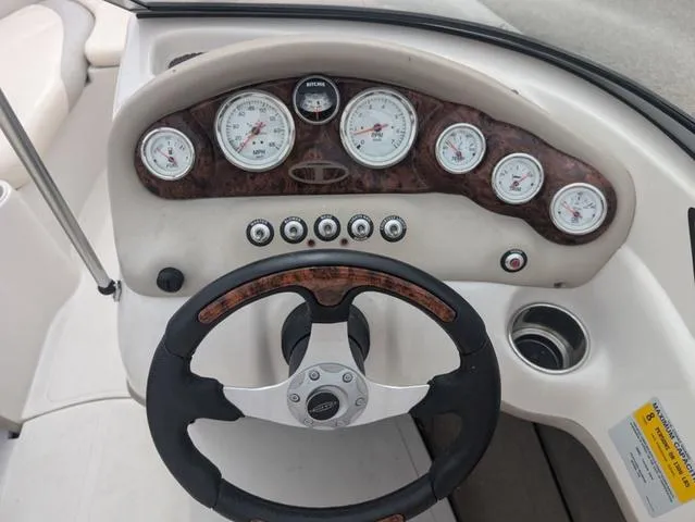 Slide: The Image of Steering wheel and dashboard of a 2010 Tahoe Q5i boat with gauges and controls. - 11