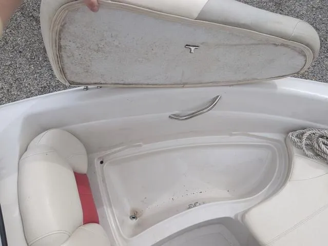 Slide: The Image of 2010 Tahoe Q5i boat interior with open storage compartment and white seating. - 15