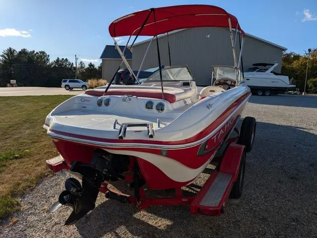 Slide: The Image of 2010 Tahoe Q5i boat with red canopy on trailer, parked outdoors. - 21