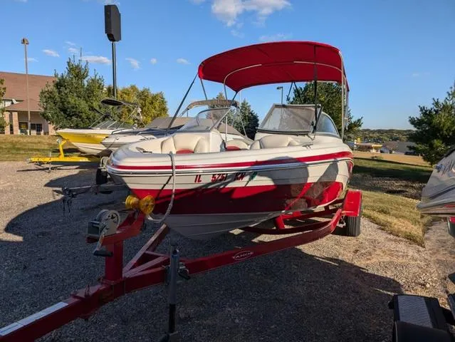 Slide: The Image of 2010 Tahoe Q5i boat with red canopy on trailer in outdoor setting. - 23
