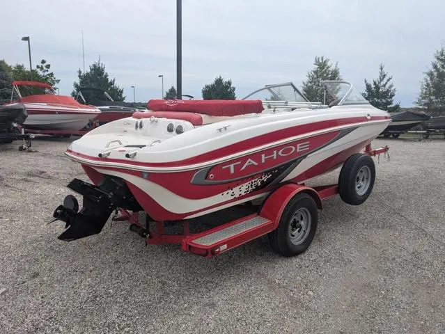 Slide: The Image of 2010 Tahoe Q5i boat on trailer, red and white design, parked outdoors. - 5