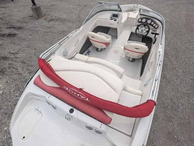 Slide: The Image of 2010 Tahoe Q5i boat with white and red interior, parked on gravel. - 6
