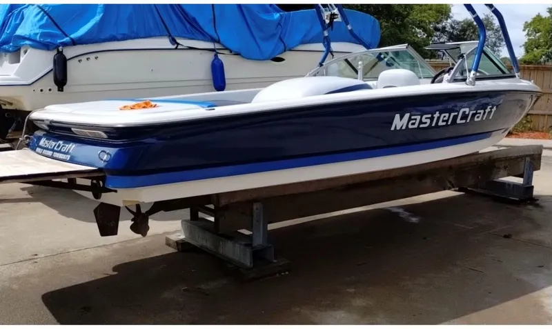 Slide: The Image of 2003 MasterCraft ProStar 197 boat on a lift, blue and white design. - 3