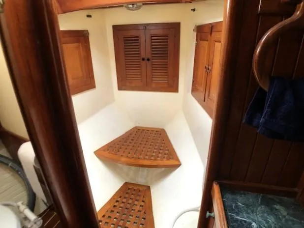 Slide: The Image of 1979 Hans Christian 38 MKII cabin interior with wooden accents and storage compartments. - 19