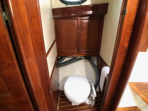 Slide: The Image of 1979 Hans Christian 38 MKII yacht bathroom with wooden cabinetry and marine toilet. - 20