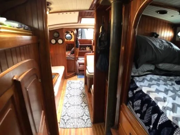 Slide: The Image of Interior of a 1979 Hans Christian 38 MKII sailboat, featuring wood paneling and cozy living space. - 21