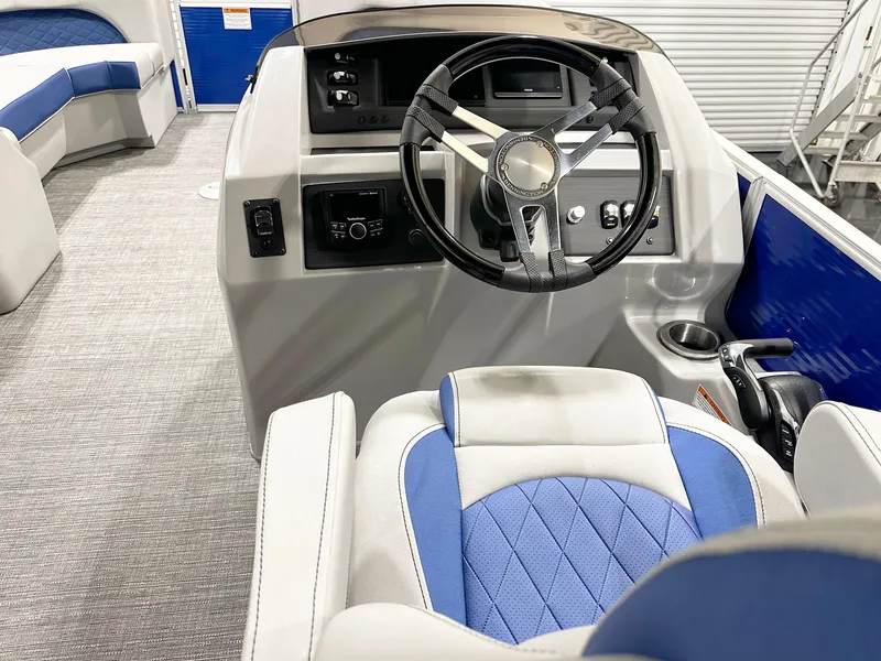 Slide: The Image of Interior of 2025 Bennington 23LFBCSR boat with steering wheel and blue seating. - 9