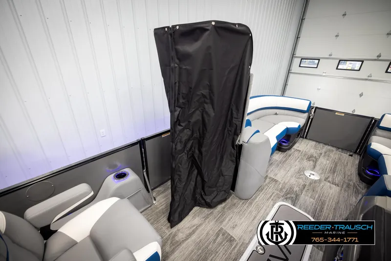 Slide: The Image of 2025 Avalon Catalina QLS boat interior with seating and privacy curtain in showroom. - 22