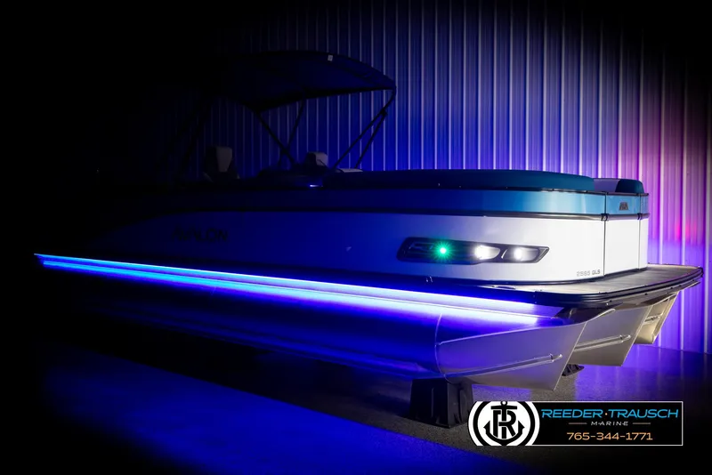 Slide: The Image of 2025 Avalon Catalina QLS pontoon boat with blue LED lights in a showroom. - 4
