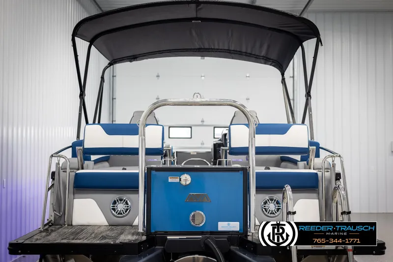 Slide: The Image of 2025 Avalon Catalina QLS pontoon boat with blue and white seating in a showroom. - 7
