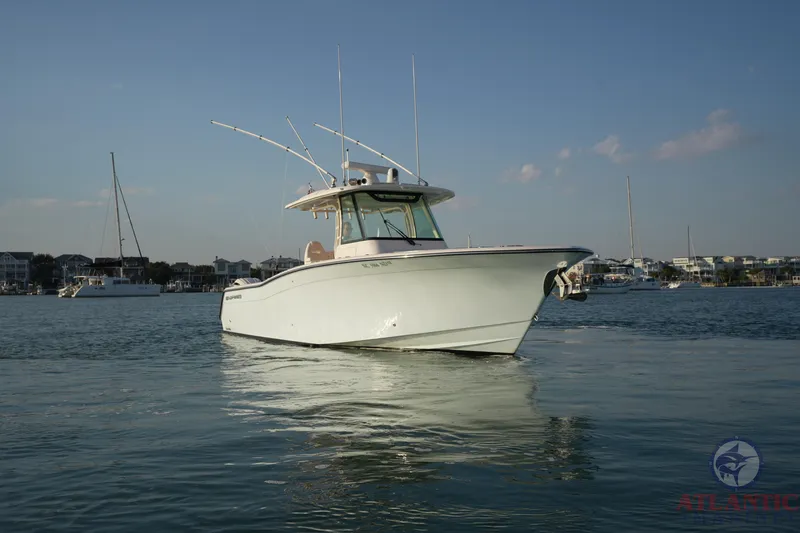 Slide: The Image of 2024 Grady-White Canyon 336 boat on calm water, clear sky background. - 1