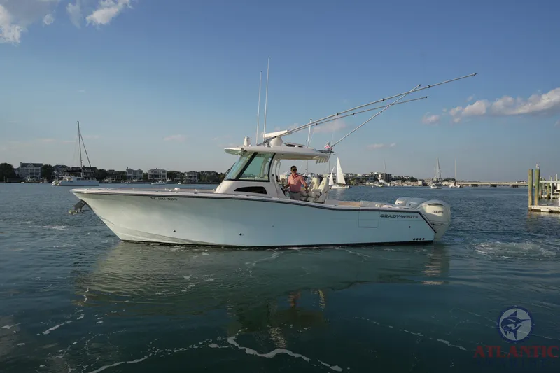 Slide: The Image of 2024 Grady-White Canyon 336 boat cruising on calm waters under a clear blue sky. - 10