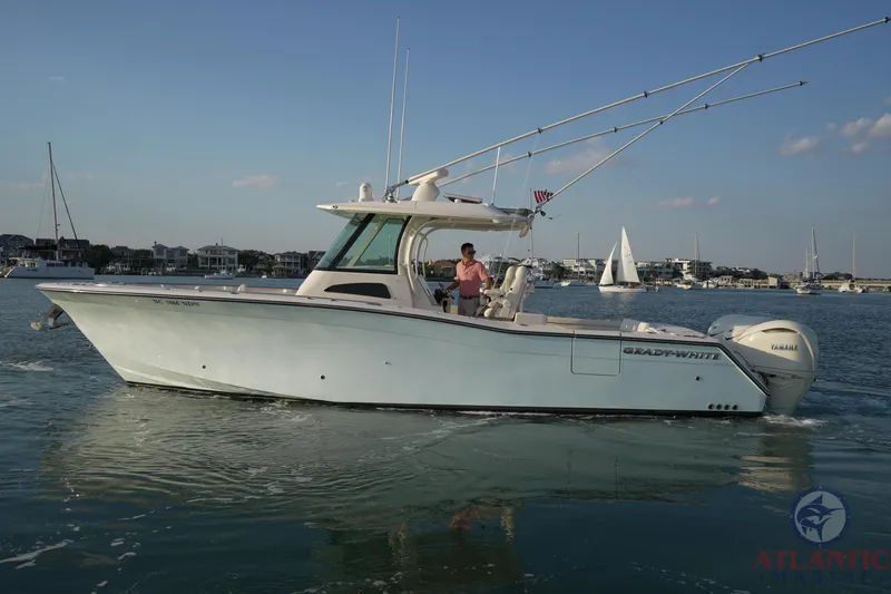 Slide: The Image of 2024 Grady-White Canyon 336 boat cruising on calm waters with a scenic backdrop. - 13