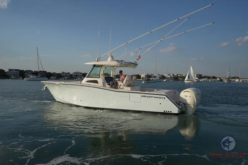 Slide: The Image of 2024 Grady-White Canyon 336 boat cruising on calm waters with a scenic backdrop. - 14
