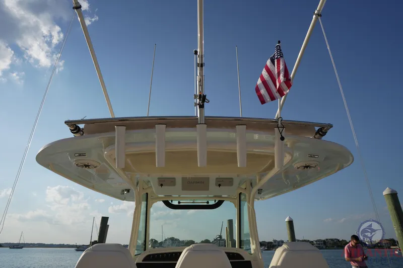 Slide: The Image of 2024 Grady-White Canyon 336 boat with American flag, viewed from the rear on a sunny day. - 35