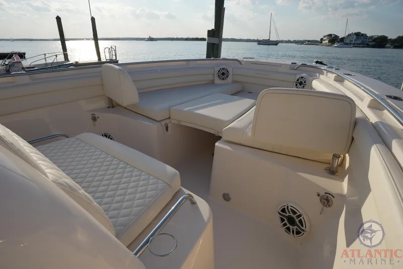 Slide: The Image of 2024 Grady-White Canyon 336 boat interior with cushioned seating, docked by the water. - 36