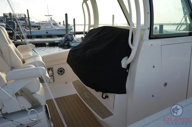 Slide: The Image of 2024 Grady-White Canyon 336 boat interior at marina, featuring seating and covered console. - 38