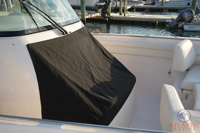 Slide: The Image of 2024 Grady-White Canyon 336 boat interior with black console cover at marina. - 39