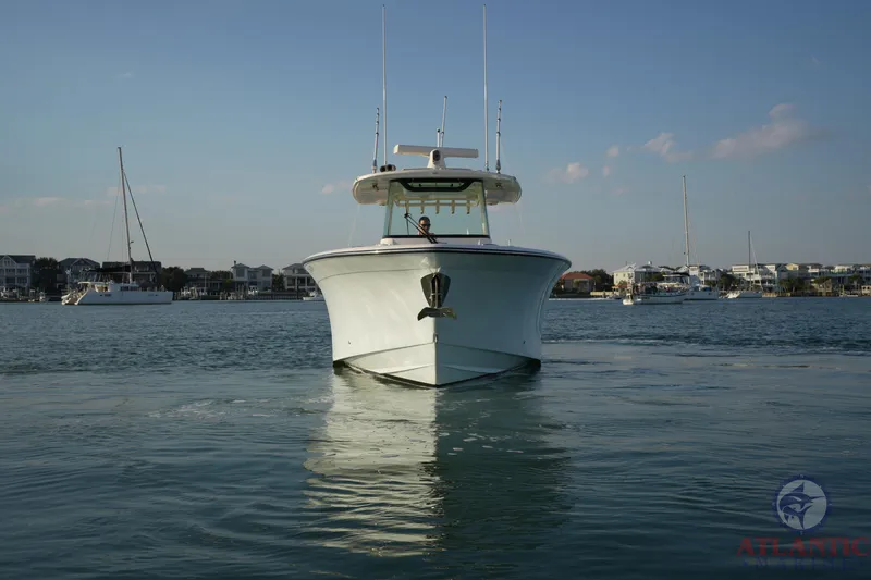 Slide: The Image of 2024 Grady-White Canyon 336 boat on calm water, front view, with marina background. - 4