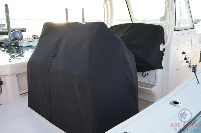 Slide: The Image of 2024 Grady-White Canyon 336 boat with covered seating, docked at marina. - 40