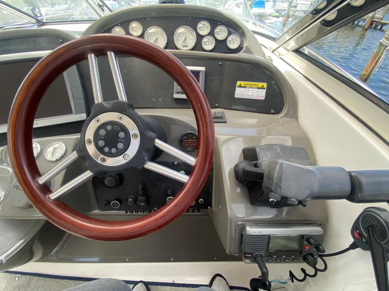 Slide: The Image of 2007 Regal 3760 Sportyacht helm with wooden steering wheel and control panel. - 26